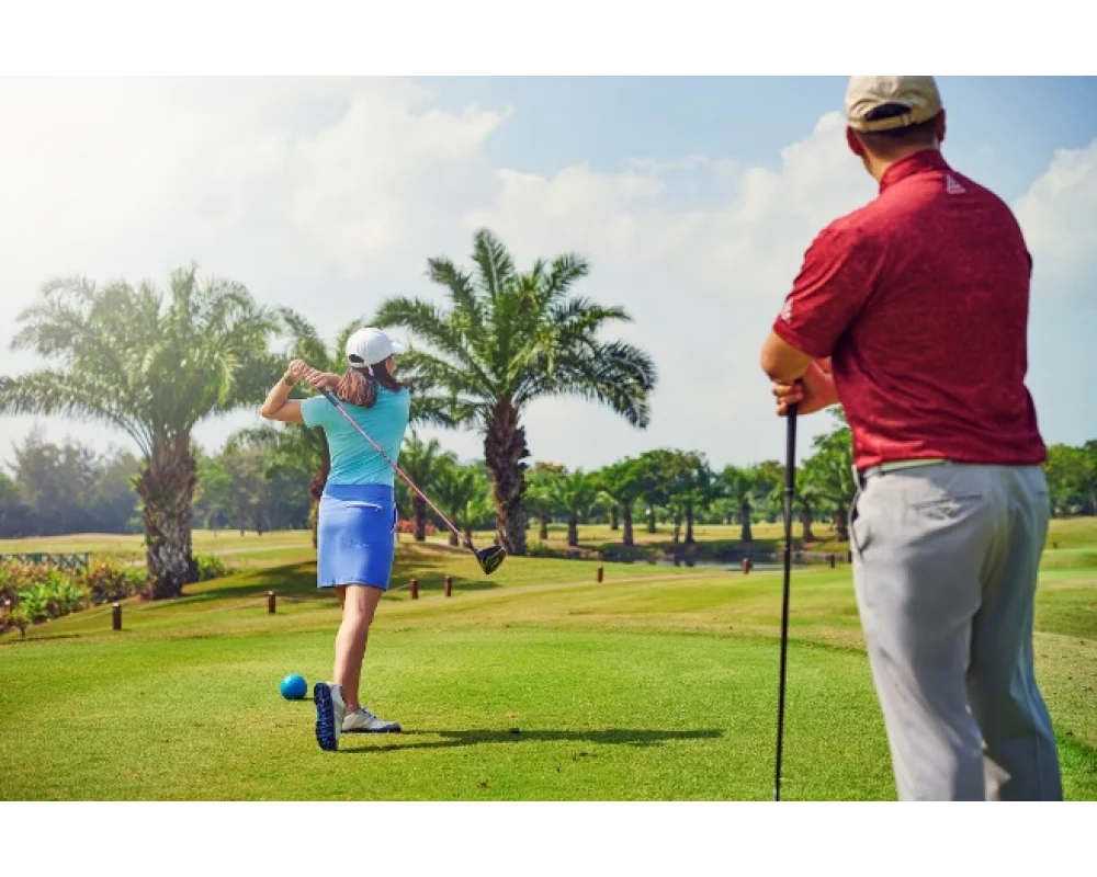 Golfer teeing off on a tropical golf course