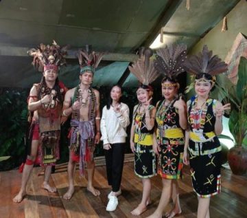 Visitors with performers in traditional Sabah clothing