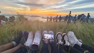 Friends relaxing together at a sunset viewpoint