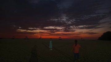 Tour group watching sunset from a grassy viewpoint