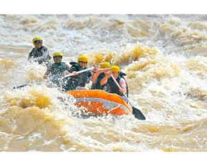 Orange raft carrying guests through white water