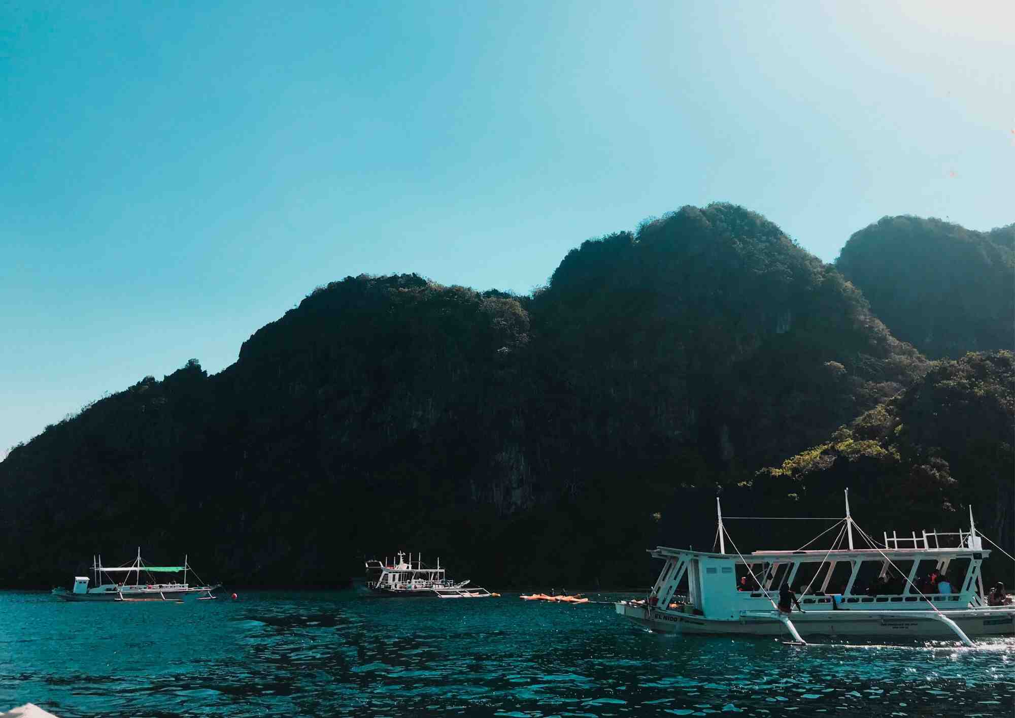 Tour boat beside a limestone island